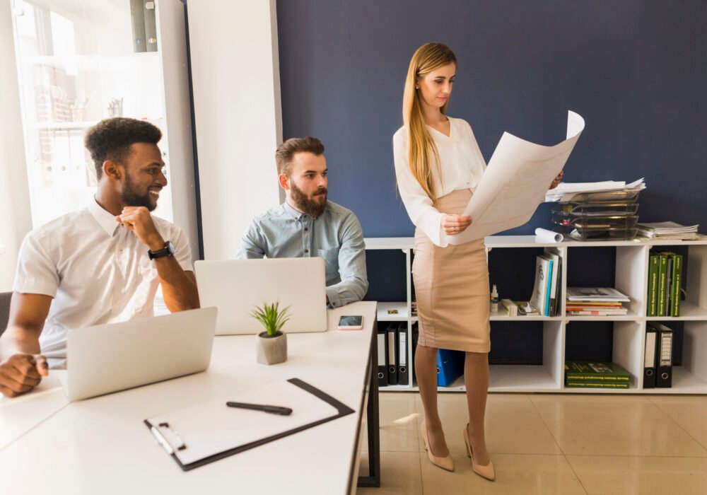 cheerful-men-looking-woman-with-blueprint